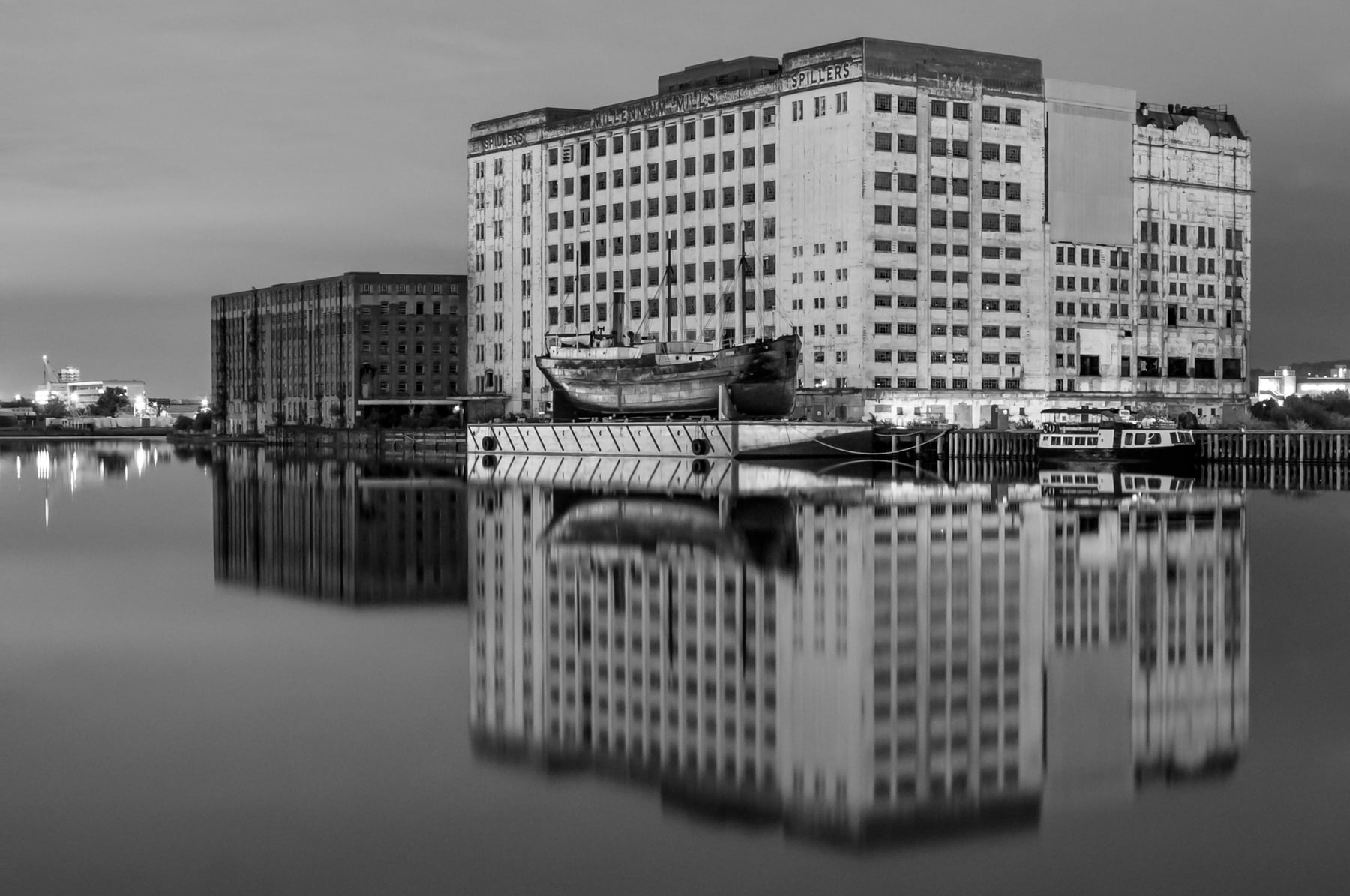 Historic mill buildings reflected in still water