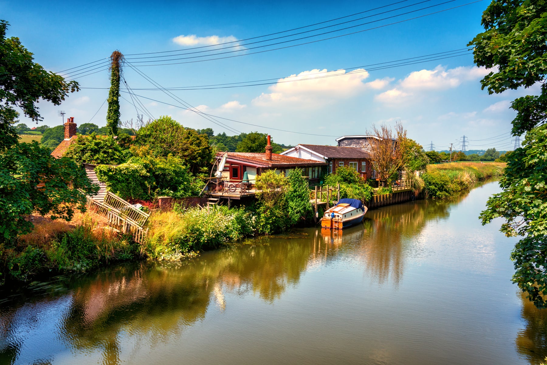 Riverside homes and a small boat in the English countryside