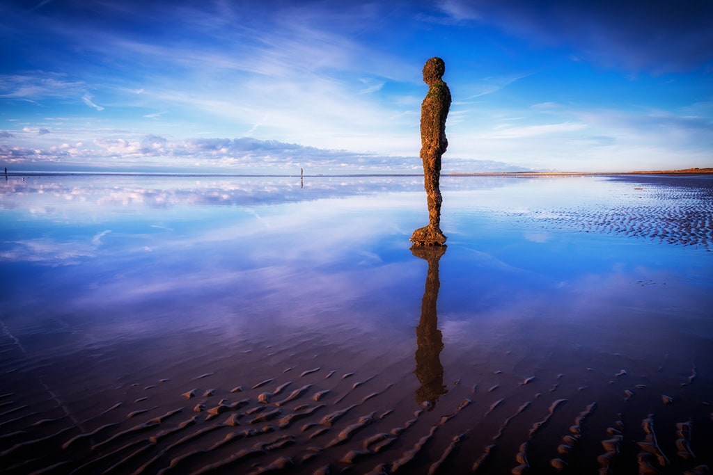 Another Place sculpture reflected on Crosby Beach