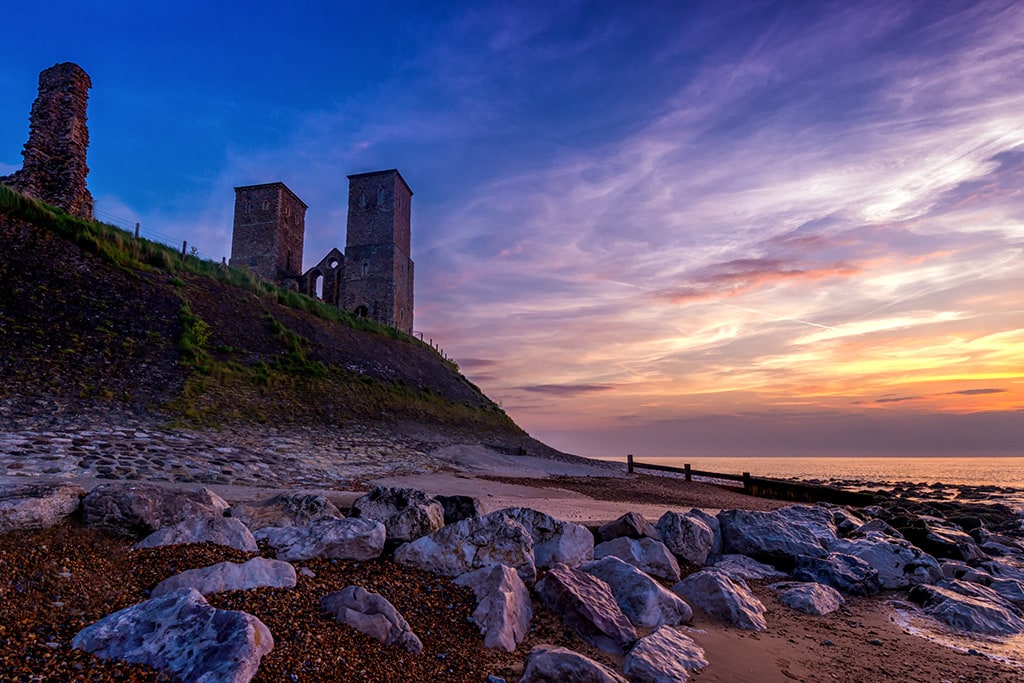 Reculver towers above the coastline at sunset