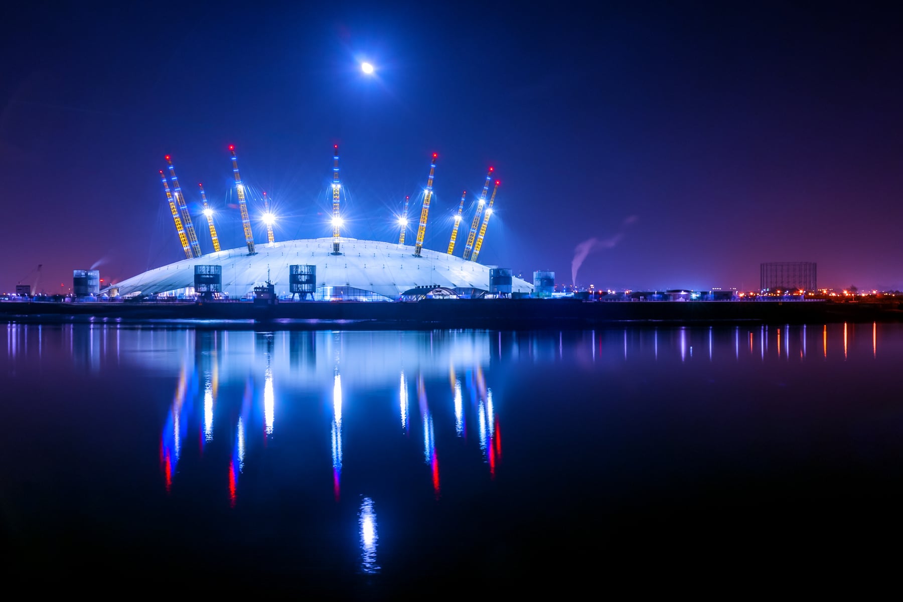 The O2 illuminated at night and reflected in the water